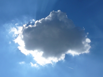 Wolke vor blauem Himmel, durch die Sonne von hinten erleuchtet